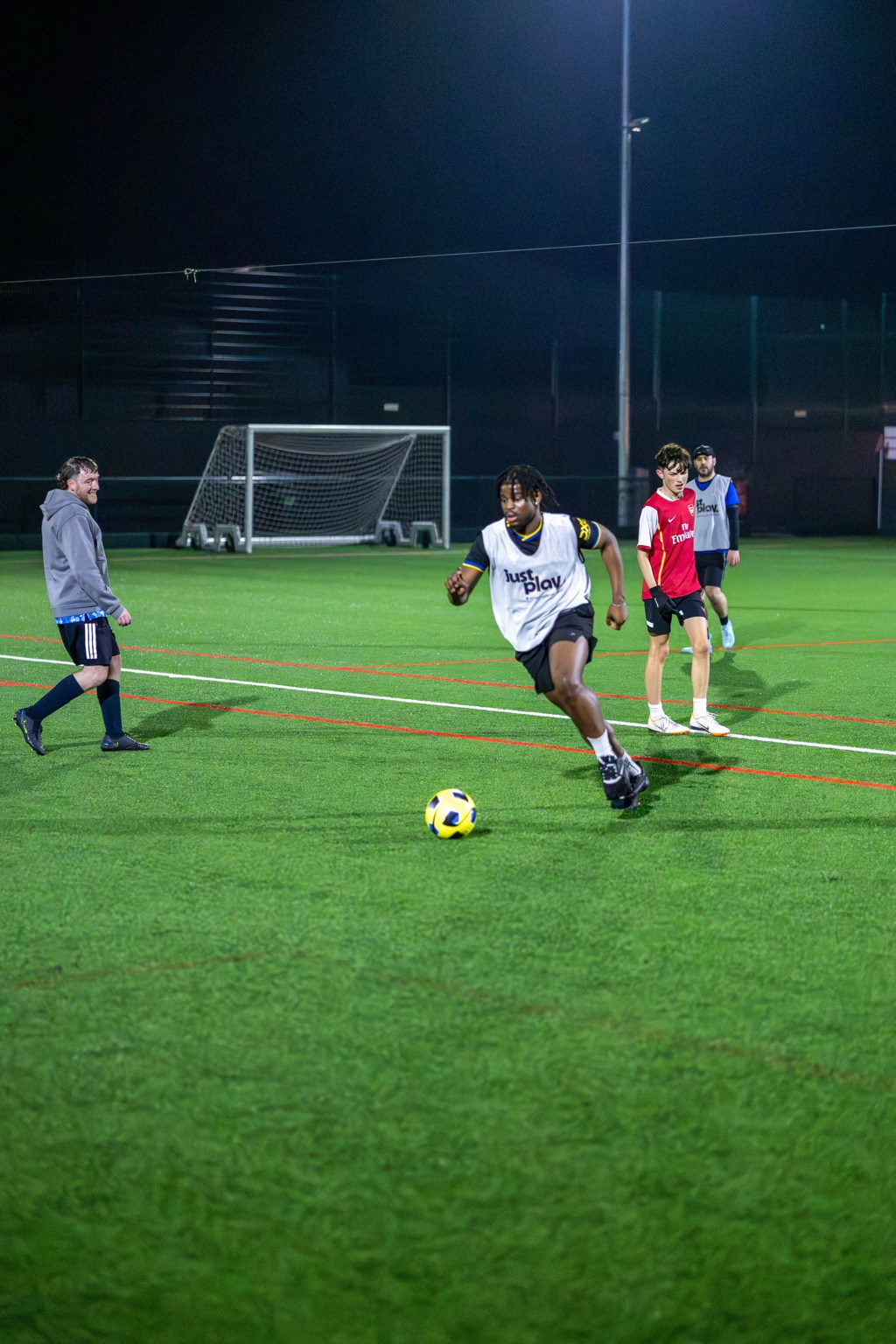 Player driving forward with the ball during an evening session